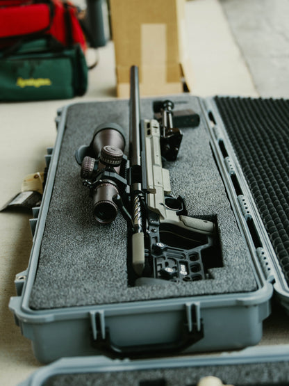 The Cheytac Perses by B&B Firearms is a green and black precision rifle chambered in .338 LM, boasting a long barrel and a large tactical scope mounted on top. Equipped with a bipod, modular stock, ergonomic grip, adjustable cheek rest, and an extended magazine, this firearm is designed for long-range shooting.