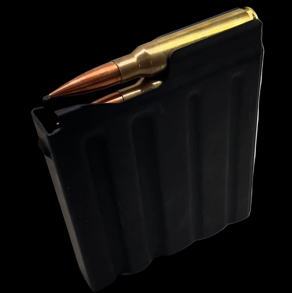 A black rectangular metal object with three vertical indentations resembles a component of the Cheytac M200 .408/.375 Magazine. The right edge features a protruding notch-like structure, and the upper right corner is slightly angled. The matte surface shows signs of mild wear, set against a solid white background. This product is manufactured by B&B Firearms.